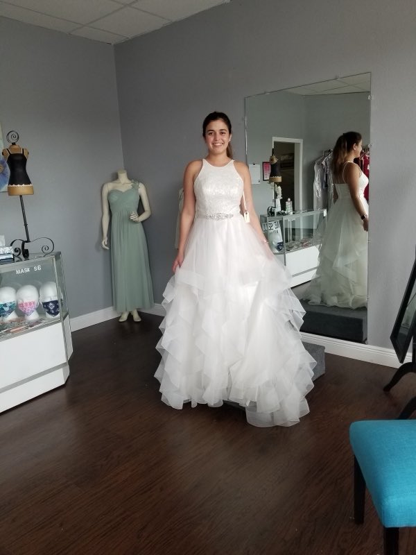 Bride smiling in a layered tulle ballgown at her final fitting