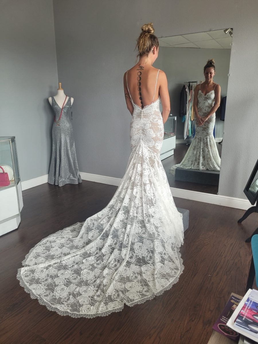 A lace wedding gown with a rose pattern and long train, altered to fit at Ana Maria Alterations